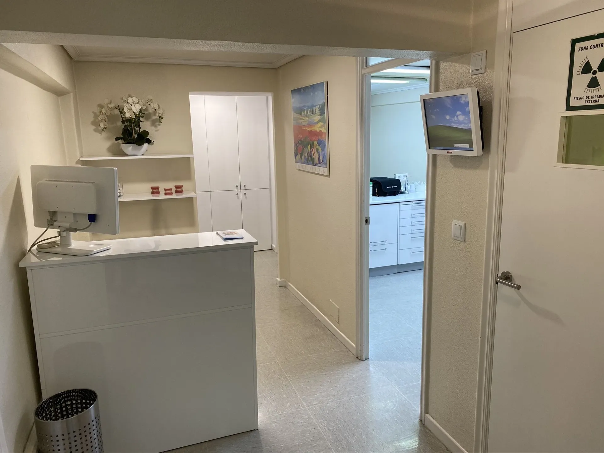 Recepción de Clínica Dental Doctor Troncoso, con orquídeas y acceso a los gabinetes