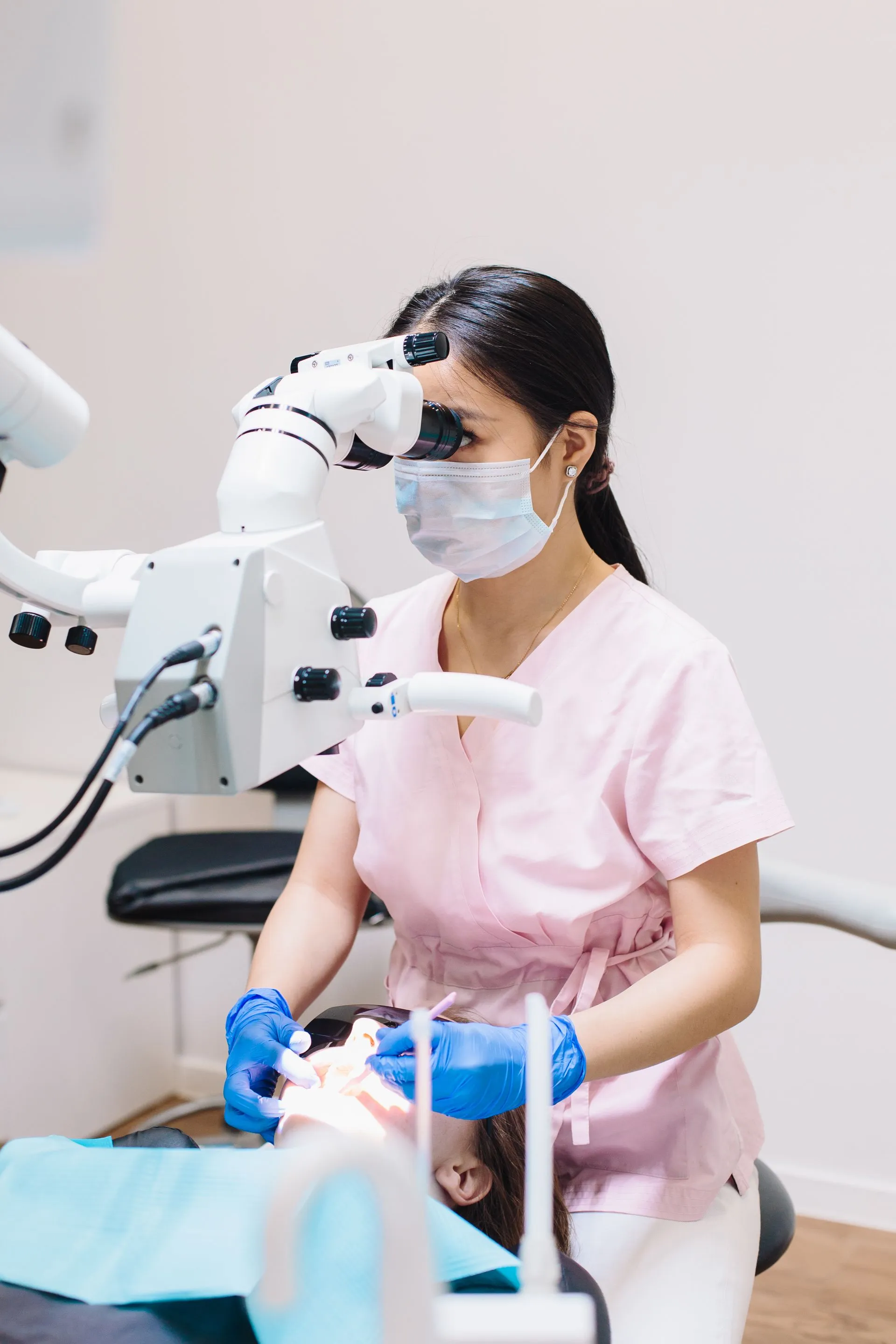 Dentista utilizando un microscopio de precisión durante un tratamiento