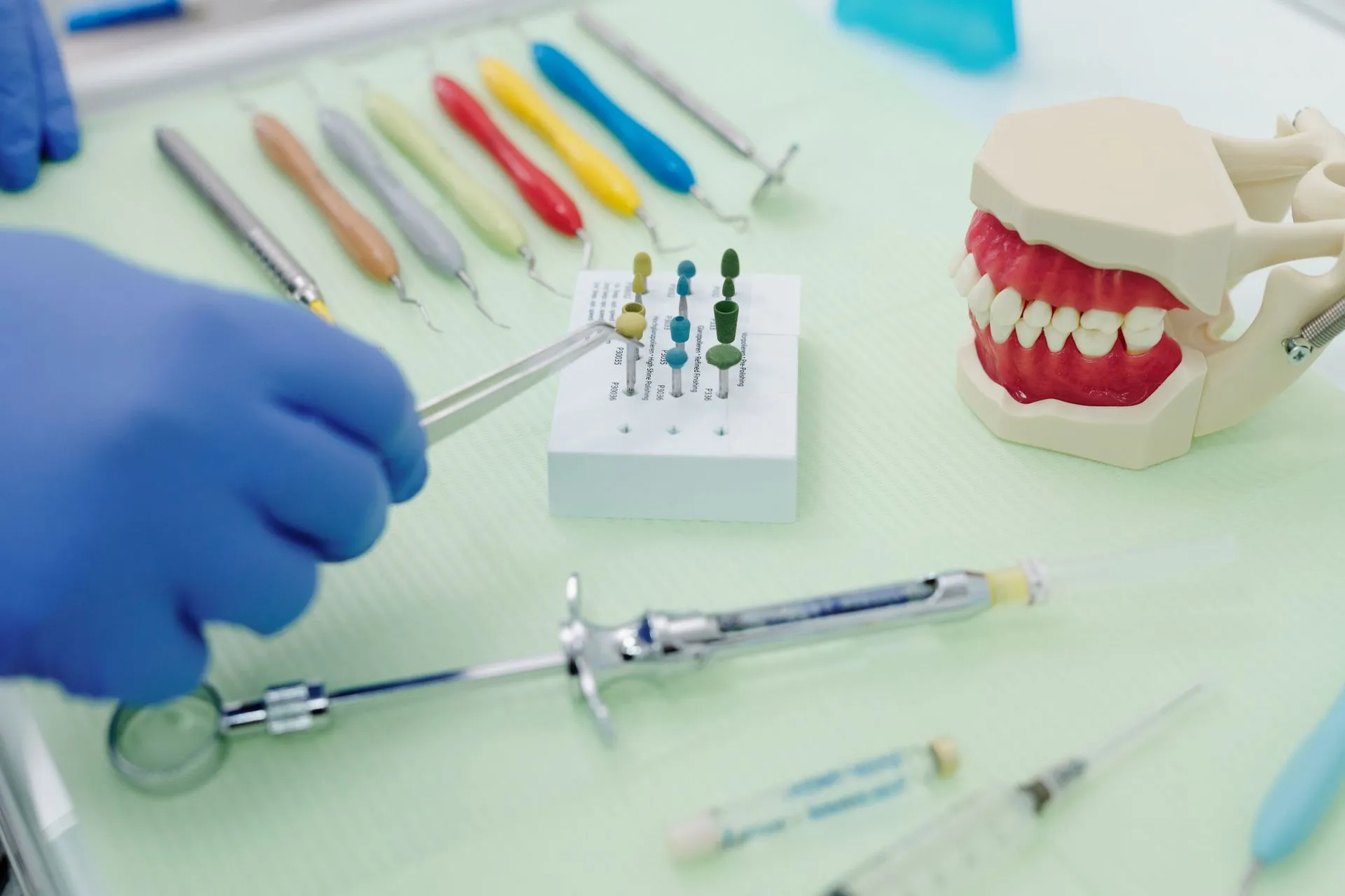 Instrumental de periodoncia junto a un modelo de mandíbula